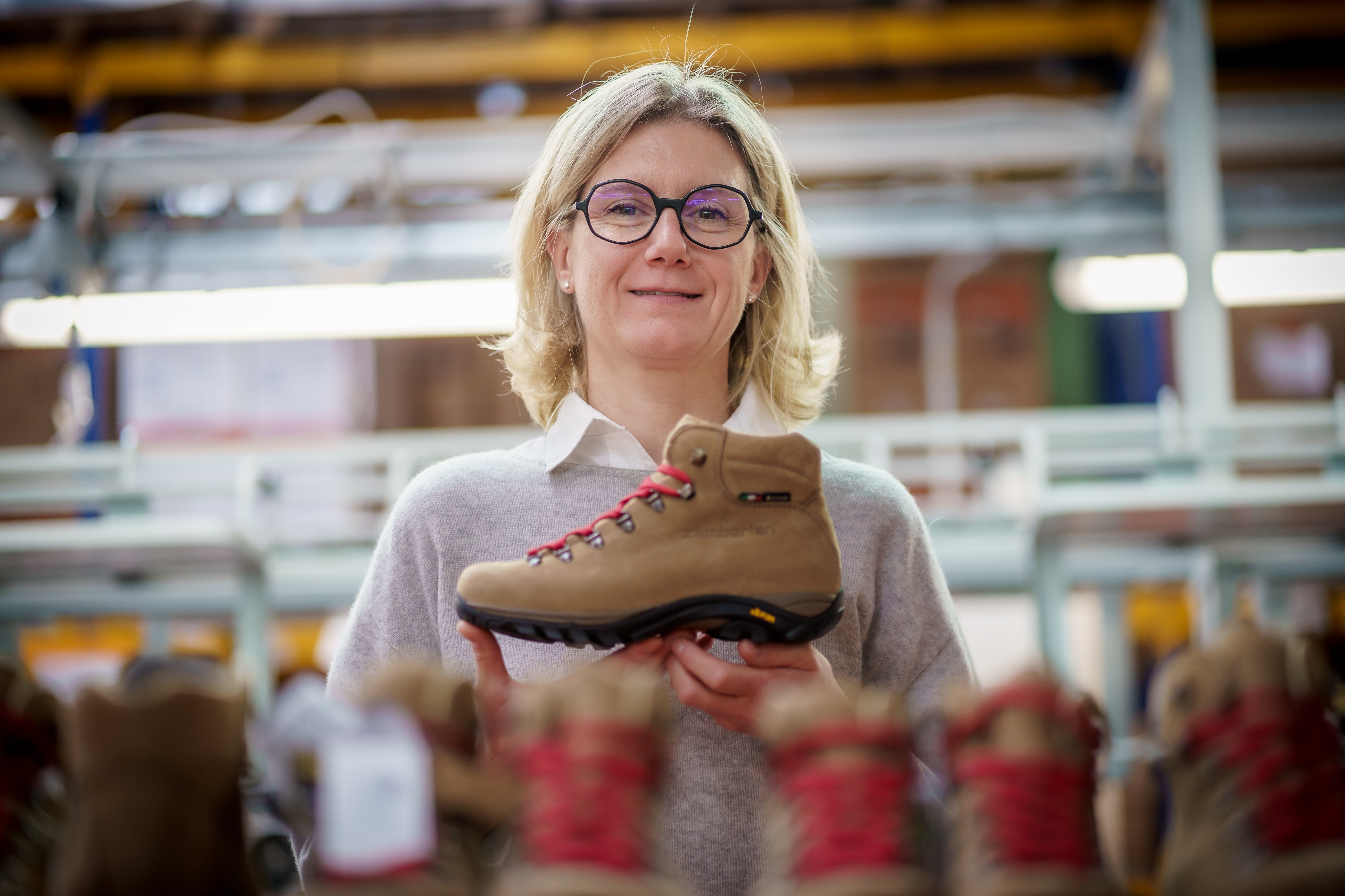A photo of Maria Zamberlan holding a Trail Lite Evo GTX women's hiking boot and smiling.