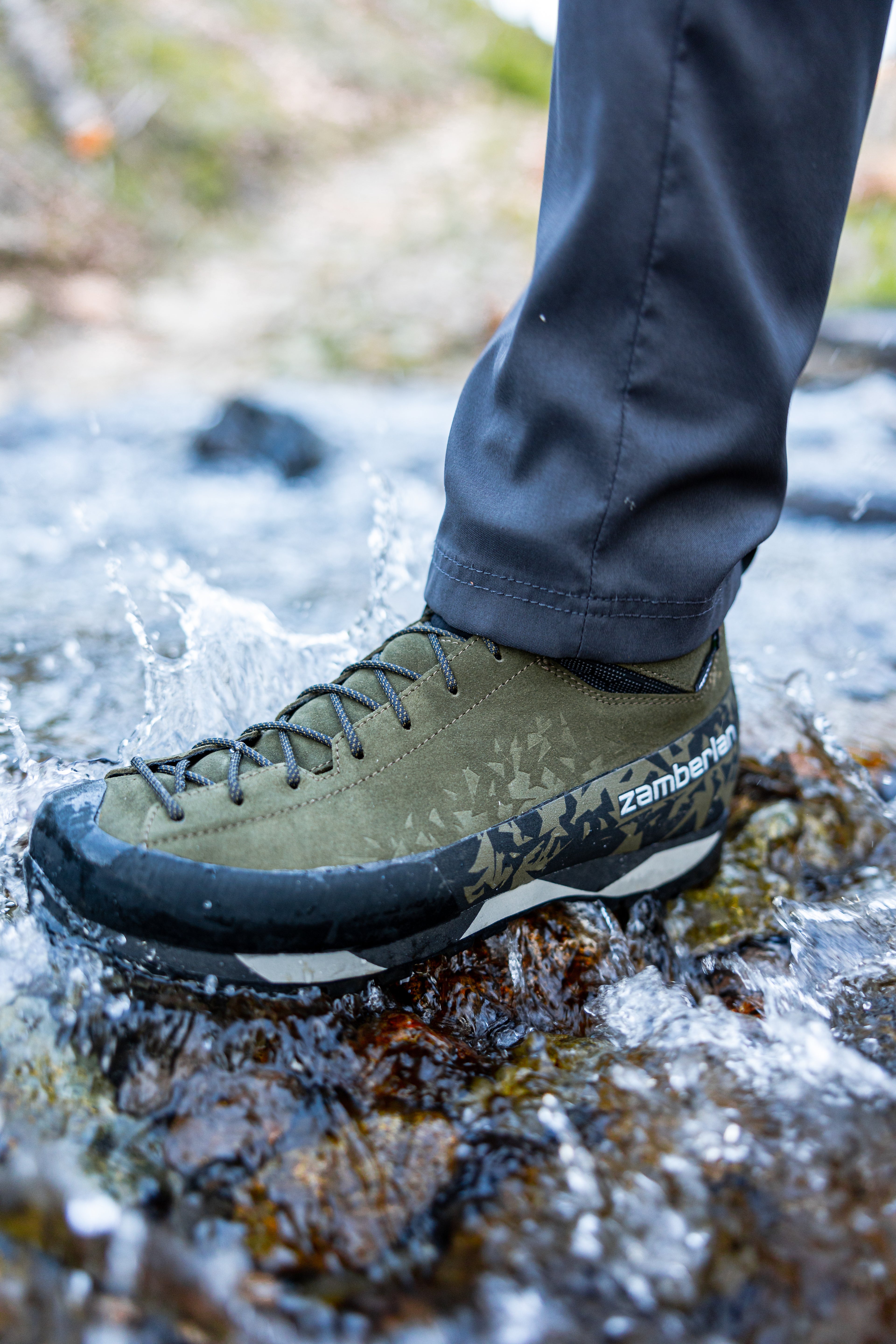 Action shot of a man walking through a creek wearing Salathe Trek boots in Olive. 