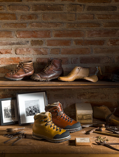 Tofane GTX RR men and women's boots displayed on a desk with shoemaking tools. 