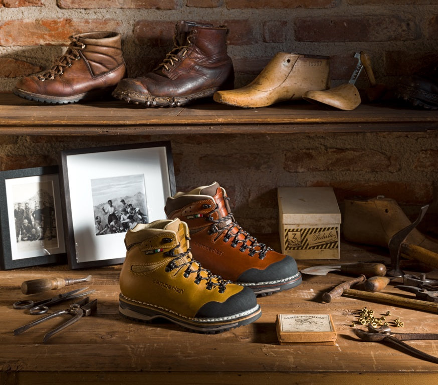 Tofane GTX RR men and women's boots displayed on a desk with shoemaking tools. 