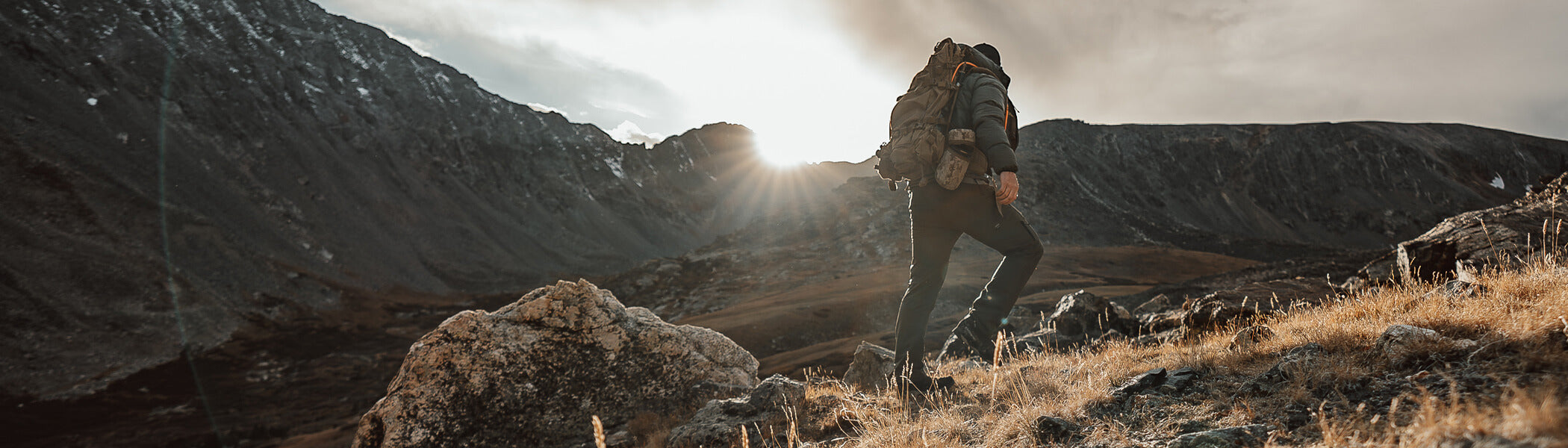 A hunter climbing rocking terrain. 