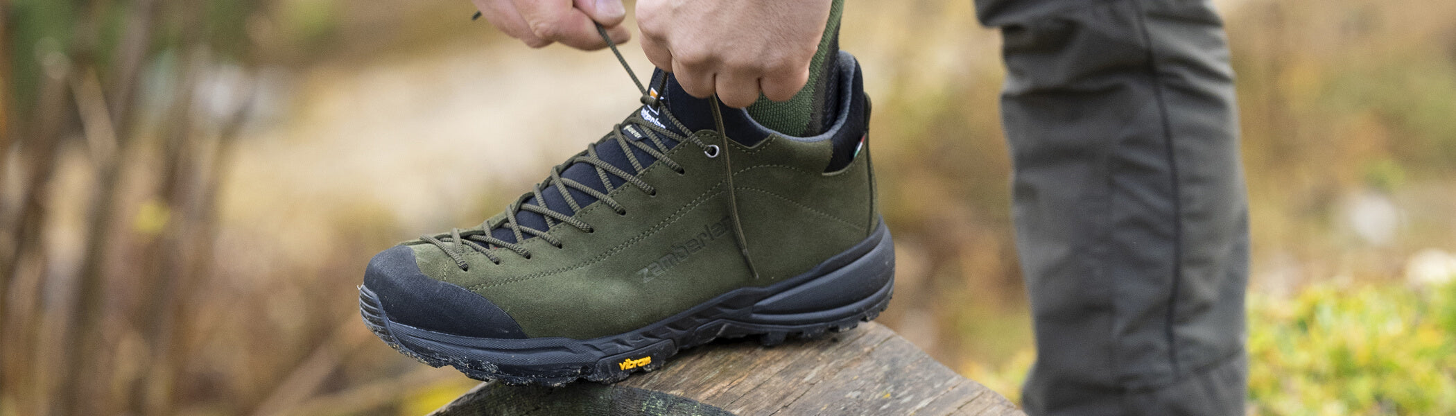 A man lacing his Zamberlan Free Blast Pro GTX in dark green. 