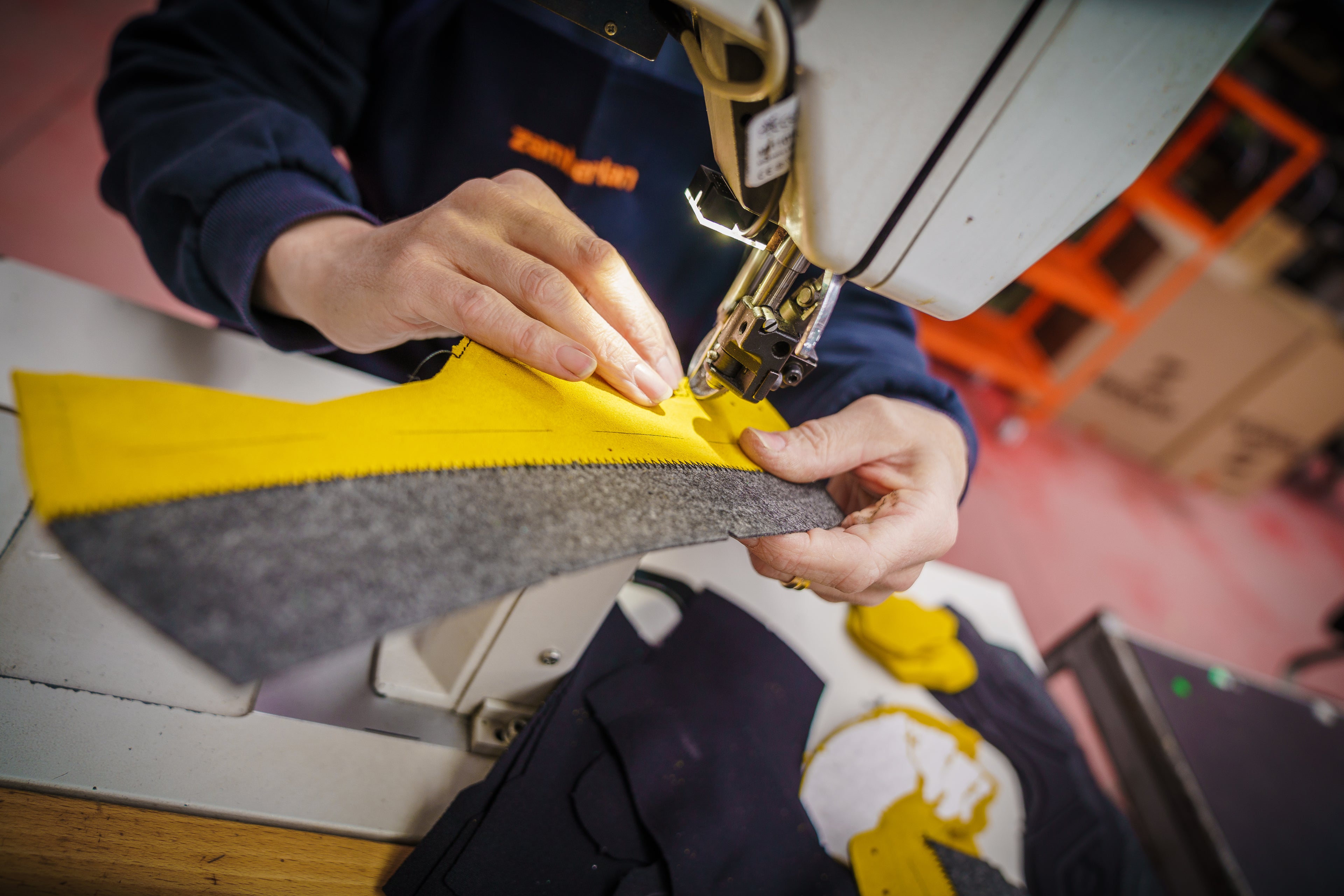 Zamberlan employee using a sewing machine to stitch material together in the factory. 