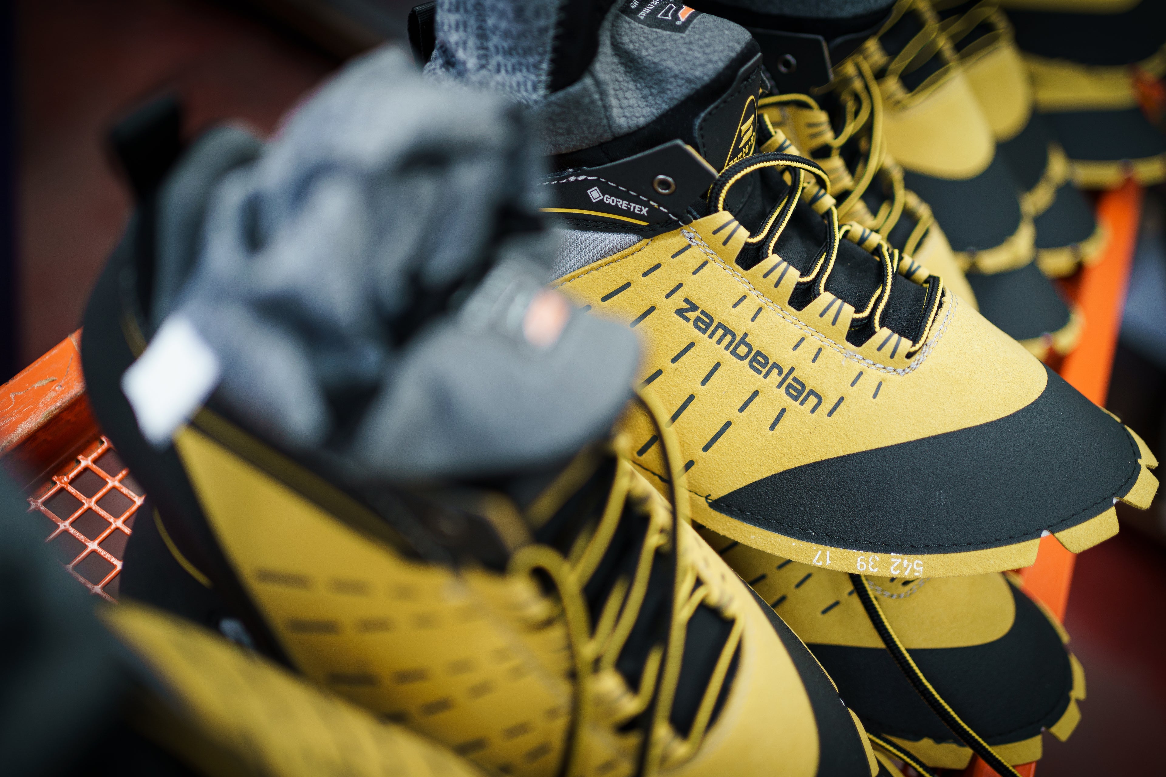 Close up of yellow Zamberlan boots being made at the Zamberlan factory. 
